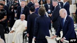 Perdana Menteri Jepang Fumio Kishida (tengah) dan Presiden Argentina Javier Milei antre untuk menyapa Paus Fransiskus di tengah sesi diskusi tentang kecerdasan buatan (AI) di KTT G7 di resor Borgo Egnazia, di Savelletri, Italia, Jumat, 14 Juni 2024. (Foto: Ludovic Marin/AFP)