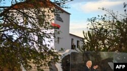 যুক্তরাষ্ট্রের প্রেসিডেন্ট জো বাইডেন , লুয়ান্ডার কাছে মোরো দ্য ক্রুজ’ এ সেখানকার ন্যাশনাল স্লেভারি মিউজিয়ামে ভাষণ দেওয়ার সময়ে অ্যাঙ্গোলার পতাকা উড়ছে। ৩ ডিসেম্বর, ২০২৪।