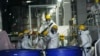 Sejumlah pria sedang bekerja menghilangkan bahan radioaktif dari air yang terkontaminasi di PLTN Fukushima Daiichi, dioperasikan oleh TEPCO, di kota Okuma, timur laut Jepang, Kamis, 3 Maret 2022. (Foto: AP)