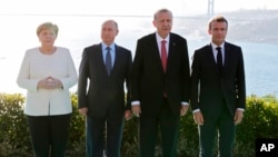 De gauche à droite: la chancelière allemande Angela Merkel, le président russe Vladimir Poutine, le président turc Recep Tayyip Erdogan et le président français Emmanuel Macron posent pour une photo lors de leur rencontre à Istanbul, en Turquie, le samedi 27 octobre 2018. (Mikhai