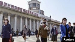 북한 평양역에서 행인들이 신종 코로나바이러스 감염을 막기 위해 마스크를 쓰고 있다.