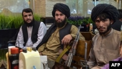 Talibanes esperan a que les sirvan la comida mientras almuerzan en un restaurante en Kabul el 26 de agosto de 2021 después de la toma militar de los talibanes tras la retirada de las tropas estadounidenses.