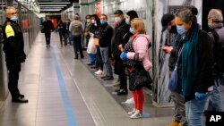 People stand apart from each other as they wait for a subway train in Rome, Italy, April 27, 2020.