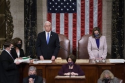 El vicepresidente de EE. UU. Mike Pence y la presidenta de la Cámara de Representantes, Nancy Pelosi, leen la certificación final de los votos del Colegio Electoral de la elección presidencial de noviembre, el 7 de enero de 2021.