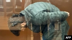 In this photo by the Moscow City Court press service on March 29, 2024, Lutfulloi Nazrimad, suspected of taking part in the Crocus City Hall attack that killed at least 143 people, stands inside the defendant cage as he waits for his hearing at Moscow's Basmanny District Court.