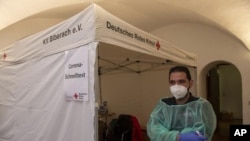 Radnik Crvenog krsta ispred šatora za testiranje na kovid u Nemačkoj (Stefan Puchner/dpa, AP)