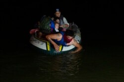 A human trafficker takes migrants, mostly from Central American countries, on a small inflatable raft towards U.S. soil in Roma, Texas Tuesday, March 30, 2021.