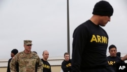 In this photo taken Tuesday, Jan. 8, 2019 Maj. Gen. Malcolm B. Frost, left, Commanding General for the U.S. Army Center for Initial Military Training, U.S. Army Training and Doctrine Command watches as troops participate in the new Army combat fitness tes