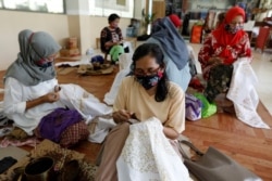 Sejumlah pekerja mengenakan masker sambil membatik di tengah pandemi virus corona (Covid-19) di Jakarta, 1 Juli 2020. (Foto: Willy Kurniawan/Reuters)