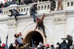 FILE - Supporters of U.S. President Donald Trump climb on walls at the U.S. Capitol during a protest against the certification of the 2020 U.S. presidential election results by the U.S. Congress, in Washington, U.S., January 6, 2021