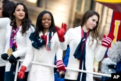 U.S. gymastics team members, from right, McKayla Maroney, Gabby Douglas and Aly Raisman ride a float in the Macy's Thanksgiving Day Parade in New York, Nov. 22, 2012.