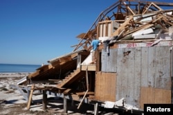 People clean up their house that was destroyed by Hurricane Michael in Mexico Beach, Fla., Oct. 13, 2018.