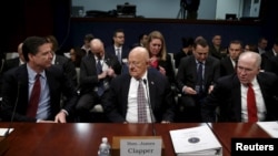 El entonces Director del FBI James Comey, el Director de Inteligencia Nacional James Clapper, y el entonces Director de la CIA John Brennan toman asiento para testificar en una audiencia en Capitol Hill en Washington en 2016.