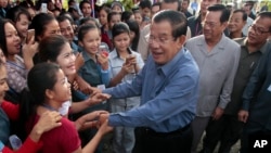 FILE - Cambodia's Prime Minister Hun Sen greets garment workers during a visit to the Phnom Penh Special Economic Zone on the outskirts of Phnom Penh, Cambodia, Aug. 23, 2017.