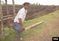 អ្នក​ភូមិ​ទួលវិហារ លោក អួន សំអាត អាយុ​៥៩​ឆ្នាំ ស្ថិត​នៅដី​ចម្ការ​របស់​លោក ដែល​លោក​សង្ស័យ​ថា​នៅ​មាន​គ្រាប់​ដែលមិនទាន់ផ្ទុះ ដែល​ត្រូវ​បាន​ទម្លាក់​ដោយ​សហរដ្ឋអាមេរិក ដើម្បី​កម្ចាត់​ពួកវៀតកុង។ (ស៊ុន ណារិន/VOA)