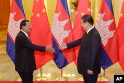 FILE - Cambodian Prime Minister Hun Sen, left, shakes hands with China's President Xi Jinping before a meeting at the Great Hall of the People in Beijing Friday, Nov. 7, 2014.