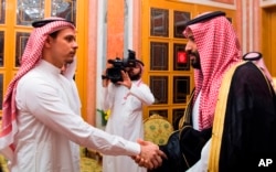 FILE - Photo released by Saudi Press Agency, SPA, shows Saudi Crown Prince Mohammed bin Salman (R) shaking the hand of Salah Khashoggi, son of Jamal Khashoggi, in Riyadh, Saudi Arabia, Oct. 23, 2018.