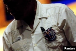 FILE - A man wears a Trump campaign button on his traditional guayabera shirt at a Hispanic Town Hall meeting with U.S. Republican presidential nominee Donald Trump and supporters in Miami, Fla., Sept. 27, 2016.