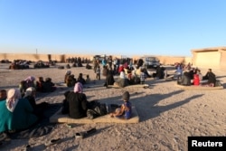FILE - Displaced families, fleeing violence in Aleppo city and from Islamic State-controlled areas in Raqqa and Deir al-Zor, sit at a school in al-Mabroukeh village in the western countryside of Ras al-Ain, Syria, Dec. 28, 2015.