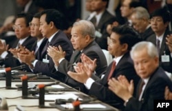 FILE - From left: Khmer Rouge factions leaders, Im Chuun Lin, Cambodian Premier Hun Sen, Dith Munty, Cambodian Prince Norodom Sihanouk, Ieng Mouly and Khieu Samphan, applaud 23 October 1991 in Paris after signning the peace treaty which ended dacades of civil war in Cambodia. (AFP/Eric Feferberg)