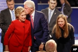 Former President Bill Clinton kisses Democratic presidential nominee Hillary Clinton as she and their daughter, Chelsea Clinton, greet supports during the presidential debate at Hofstra University in Hempstead, N.Y., Sept. 26, 2016.