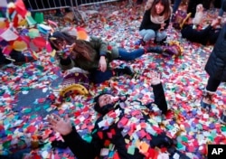 Revelers throw confetti on themselves after after celebrating the new year in Times Square, Sunday, Jan. 1, 2017, in New York.