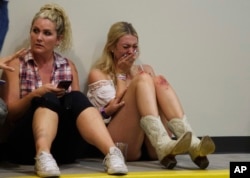 A woman cries while hiding inside the Sands Corporation plane hangar after a mass shooting in which dozens were killed at the Route 91 Harvest country festival on Oct. 1, 2017, in Las Vegas.