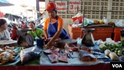 A fish merchant cuts up fish at a local market in Chiang Khan town, Thailand, July 25, 2016. (Neou Vannarin/VOA Khmer)