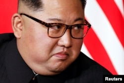 North Korea's leader Kim Jong Un listens to U.S. President Donald Trump as they meet in a one-on-one bilateral session at the start of their summit at the Capella Hotel on the resort island of Sentosa, Singapore, June 12, 2018.