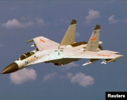 FILE - A Chinese J-11 fighter jet is seen flying near a U.S. Navy P-8 Poseidon about 215 km (135 miles) east of China's Hainan Island in this U.S. Department of Defense handout photo taken, Aug. 19, 2014.