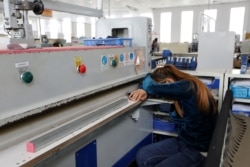 FILE - A worker has a nap at Complete Honour Footwear Industrial, a footwear factory owned by a Taiwan company, in Kampong Speu, Cambodia, July 4, 2018.