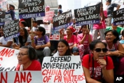FILE - Protesters shout slogans denouncing China during a rally outside of the Chinese Consulate hours before the Hague-based U.N. international arbitration tribunal announced its ruling on South China Sea, July 12, 2016.