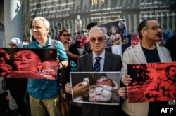 Participants hold pictures children during a protest of Turkish activists and Syrians living in Istanbul against the latest bombardment of Aleppo by the Syrian regime and its military allies, on Istiklal avenue in Istanbul, Oct. 1, 2016.