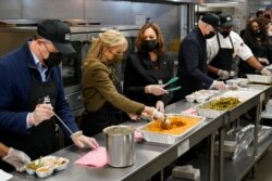 Rais Joe Biden, Mkewe Jill Biden, Makamu wa Rais Kamala Harris, na mumewe Doug Emhoff, wakitayarisha mifuko ya chakula cha Thanksgiving wakati walipotembelea Jiko la DC Central, Washington, Jumanne, Nov. 23, 2021.