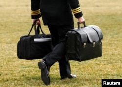 A military aide, carrying the "football" containing launch codes for nuclear weapons, accompanies U.S. President Donald Trump onto Marine One upon Trump's departure from the White House in Washington, Feb. 3, 2017.