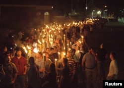 FILE - White nationalists carry torches on the grounds of the University of Virginia, on the eve of a planned "Unite the Right" rally in Charlottesville, Va., Aug. 11, 2017.