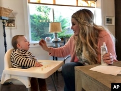 Jocelyn Smith cares for her 11-month-old son, Mason at their home in Camas, Wash., Jan. 30, 2019. Smith has been afraid to take Mason out of the house during a measles outbreak in southwest Washington because he is too young to receive the measles vaccine
