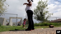 FILE - A woman who said she entered the United States illegally, watches over her daughter, who was born in the U.S., in Sullivan City, Texas, Sept. 16, 2015.