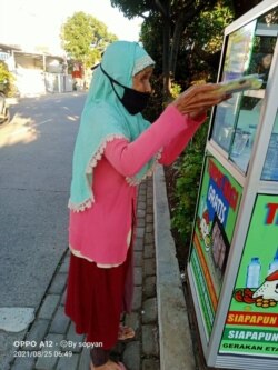 Seorang ibu mengambil nasi gratis. (Foto: Courtesy)