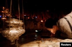 A worshipper kisses the star inside the cave at the Church of the Nativity, in Bethlehem in the Israeli-occupied West Bank, Dec. 23, 2018.