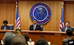 Federal Communications Commission (FCC) Chairman Ajit Pai, center, announces the vote was approved to repeal net neutrality, next to Commissioner Mignon Clyburn, left, who voted no, and Commissioner Michael O'Rielly, who voted yes, at the FCC, Dec. 14, 20