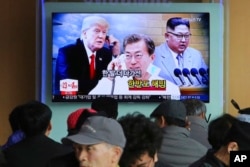 People watch a TV screen showing images of North Korean leader Kim Jong Un, right, South Korean President Moon Jae-in, center, and U.S. President Donald Trump at the Seoul Railway Station