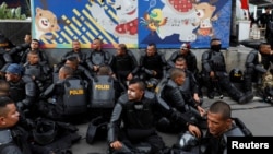 Police officers rest during a protest following the announcement of last month's election official results outside Indonesia's Election Supervisory Agency headquarters in Jakarta, Indonesia, May 22, 2019.