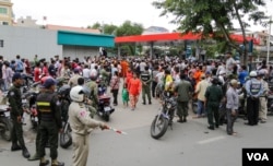 រូបឯកសារ៖ ប្រជាពលរដ្ឋ​ជុំ​គ្នា​នៅ​ខាង​ក្រៅ​ហាង Star Mart ​នៃ​ស្ថានីយ៍ប្រេងឥន្ធនៈ Caltex កន្លែង​ដែលសាកសព លោក កែម ឡី ដេក​ដួល​នៅខាងក្នុងនោះ។ (ឡេង ឡែន/VOA)