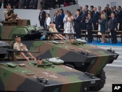 FILE - Tanks parade past President Donald Trump, first lady Melania Trump, French President Emmanuel Macron and his wife Brigitte Macron, during Bastille Day parade on the Champs Elysees avenue in Paris, Friday, July 14, 2017. (AP Photo/Carolyn Kaster)