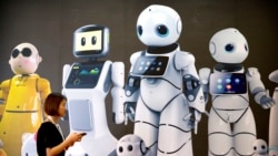 A visitor walks past a mural displaying robots from Chinese robot maker Canbot at the World Robot Conference in Beijing, China, Wednesday, Aug. 15, 2018.