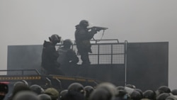 Kazakh law enforcement officers are seen on a barricade during a protest triggered by fuel price increase in Almaty, Kazakhstan Jan. 5, 2022.