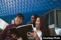 Students read informational materials about the special student job program at Ryerson University in Toronto, Canada.