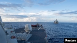 The Arleigh Burke-class guided-missile destroyer USS Dewey prepares for a replenishment-at-sea in the South China Sea.