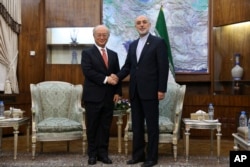 Head of Iran's Atomic Energy Organization Ali Akbar Salehi, right, and Director General of the International Atomic Energy Agency (IAEA) Yukiya Amano shake hands for the media during their meeting in Tehran, Iran, Sept. 20, 2015.
